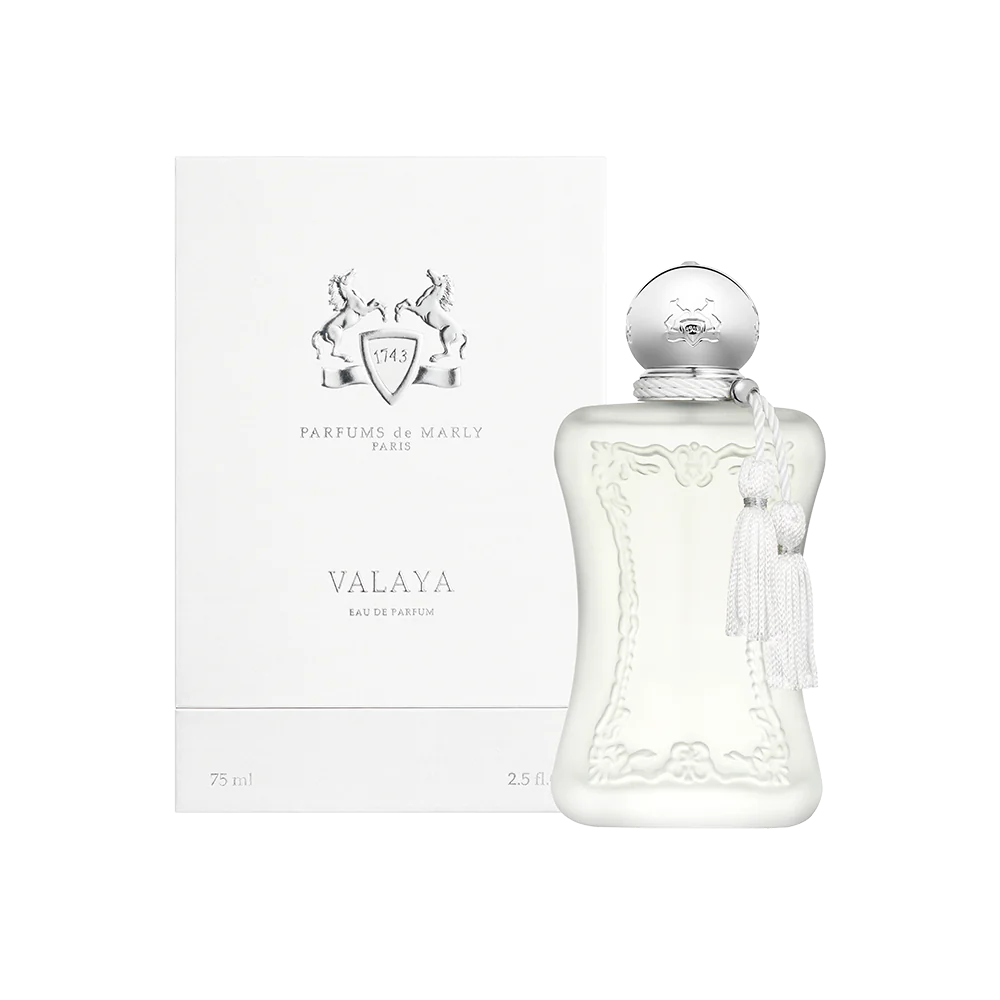 Stylized perfume flat lay with soft focus and floral background elements.