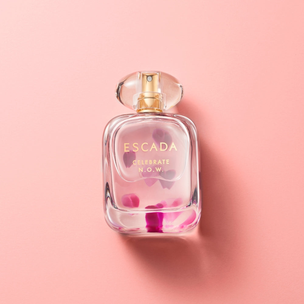 Festive-themed perfume gift box with celebratory ribbons and sparkling background.
