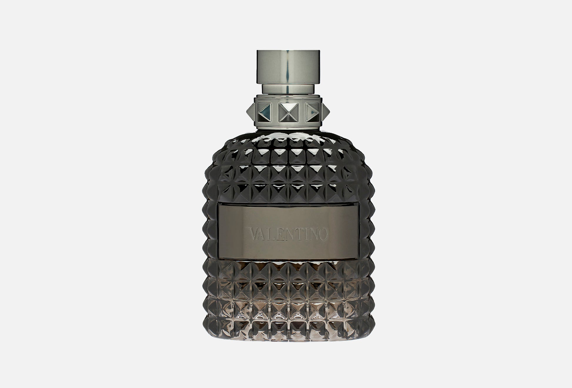 A textured dark gray bottle of Valentino Uomo fragrance with a metallic cap and a silver-toned brand plaque on the front, set against a plain light gray background.